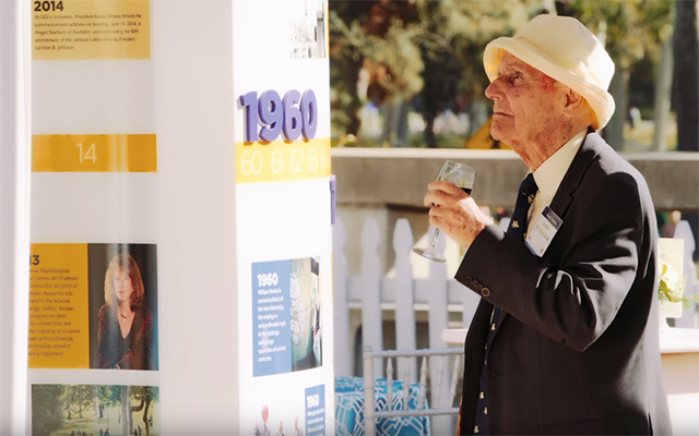 Harry Colin Slim, a founding faculty member and former chair of the Department of Music, admires a 50th Anniversary exhibit at the Founder's Day celebration.